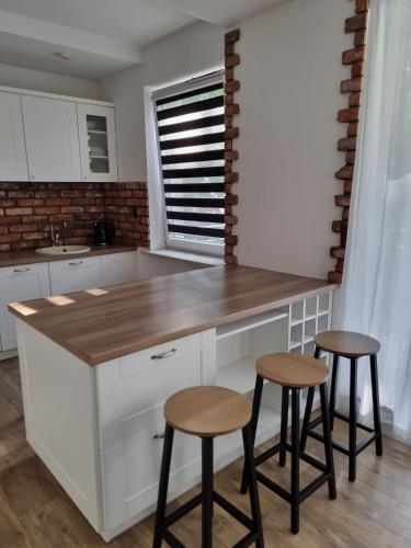 a kitchen with a counter and two stools at Apartament Słoneczne Giżycko in Giżycko