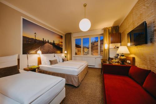 a hotel room with two beds and a couch at Metropolitan Old Town Hotel - Czech Leading Hotels in Prague