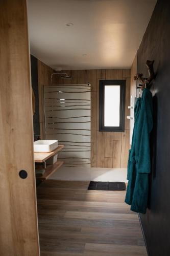 a bathroom with a tub and a sink in a room at Nordic Lodge Vosges - Helsinki - bain nordique - petit déjeuner in Saint-Léonard