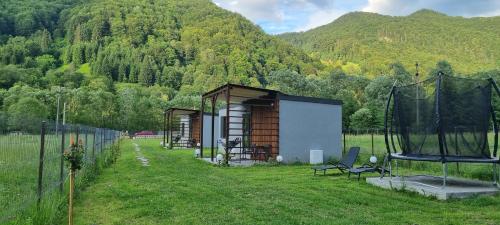 a small shed in a field next to a mountain at Tiny Teo Sătic in Satic
