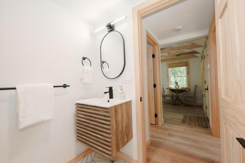 a bathroom with a sink and a mirror at BrookHaus - Modern Cabin Stay at Harvard Brook in Lincoln