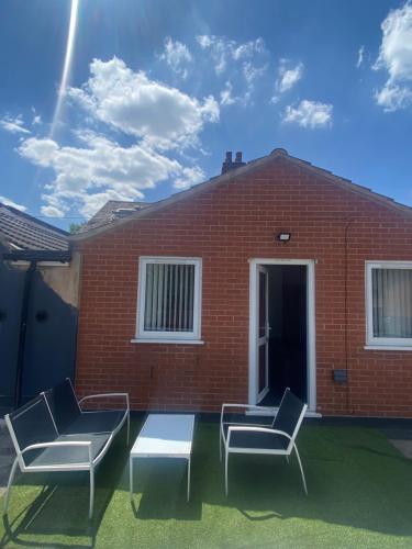 a patio with two chairs and a table in front of a brick building at LT 3 - 1 Bed Apartment in Leicester