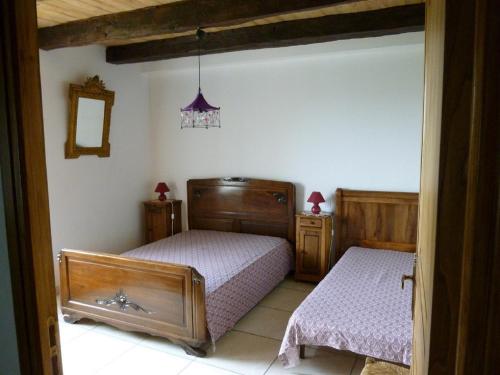 a bedroom with two beds and a mirror at Gîte à la ferme in Pachins