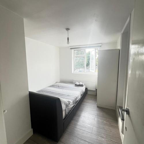 a small bedroom with a bed and a window at Small En-suite in Enfield Lock