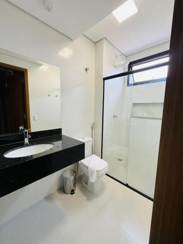 a bathroom with a toilet and a sink and a shower at Rota Hotéis Rio Verde in Rio Verde