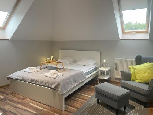 a bedroom with a bed with a table and a chair at Ostoja Dziarnówko - willa z ogrodem na Mazurach in Iława