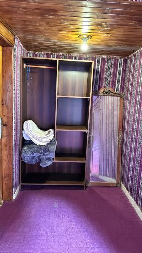 een lege kast in een kamer met paars tapijt bij Sultan rum magic camp in Aqaba