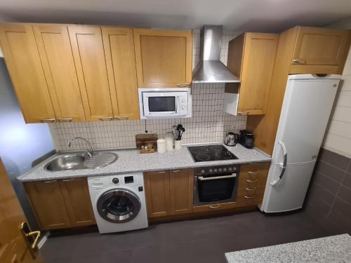 eine kleine Küche mit Spüle und Kühlschrank in der Unterkunft Amplio apartamento 2 Dormitorios 4Pax Decoración moderna in Madrid
