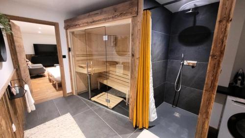 une douche avec une porte vitrée dans une salle de bain dans l'établissement Résidence PremiÈre Loge - Magnifique chalet, prestations de qualité, bel emplacement MAE-3371, aux Gets