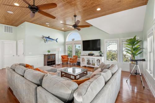 un soggiorno con un grande divano e una TV di Happy Hour a Nags Head