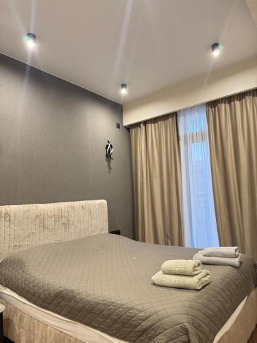 a bedroom with a bed with two towels on it at Fatmanis 98 in Tbilisi City