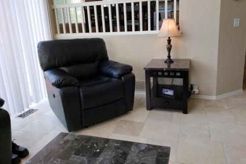 a black chair in a living room with a table at Luxurious Highlands Ranch Home with private hot tub in Littleton