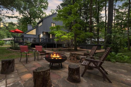 a fire pit in a yard with chairs and a house at La Maison du Lac in Sawyer