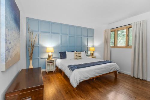 a bedroom with a large bed with a blue headboard at La Maison du Lac in Sawyer