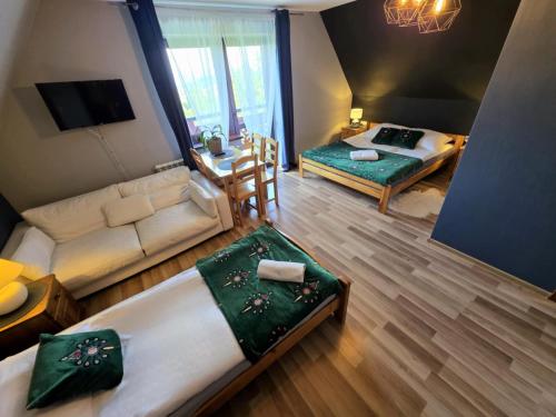 Pokój z 2 łóżkami, kanapą i stołem w obiekcie Harmatówka w Bukowinie Tatrzańskiej