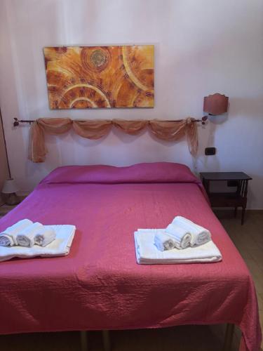 a bedroom with a red bed with towels on it at Agriturismo Fattoria Del Colle By Enrico in Casa Cappanera