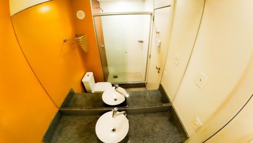 a bathroom with two sinks and a mirror at Hotel Innove Guaíba in Guaíba