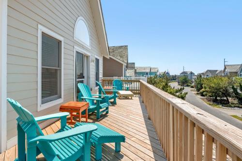 a deck with blue chairs on a house at Harrells Retreat in Nags Head