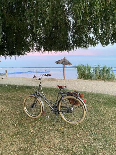 a bike parked next to a beach with an umbrella at Peter`s Lucky Home Balaton, Vonyarcvashegy in Vonyarcvashegy