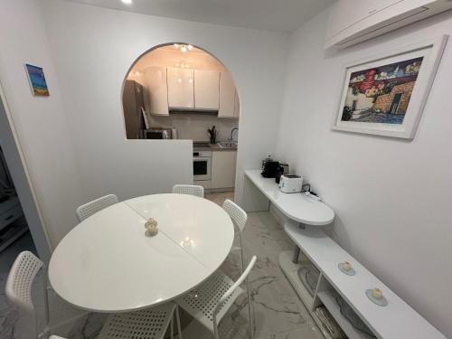 a white dining room with a white table and chairs at Villa Nada in Banići