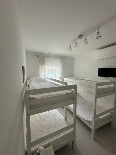 a white bedroom with two bunk beds in it at Villa Nada in Banići