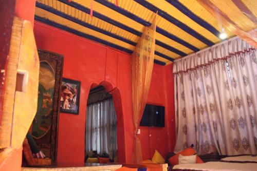 a room with red walls and a bed and curtains at House Of Shambhala in Lhasa