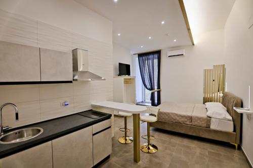 a small kitchen with a bed and a sink in a room at Dante Luxury Rooms in Naples