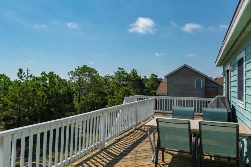 a deck with two chairs and a table on it at Haven Of Rest in Nags Head