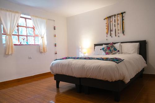 a bedroom with a bed and a window at La Rosa Wellness Lodge in Urubamba