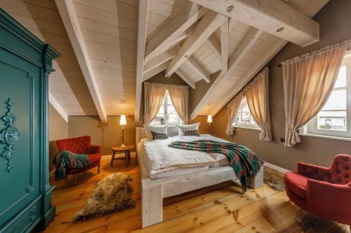 a bedroom with a bed and two chairs at Landhaus-zum-Wilddieb in Ilsenburg