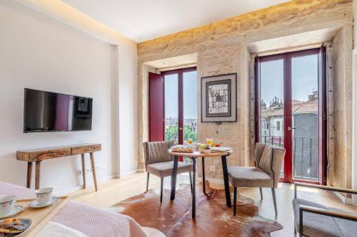 a living room with a table and chairs and windows at Decor Studios - Clérigos by Host Wise in Porto