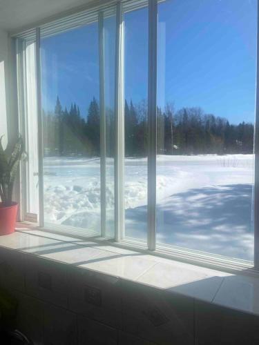 a window in a room with snow on the ground at Chalet serenity at Lac Desroches in Saint-Calixte
