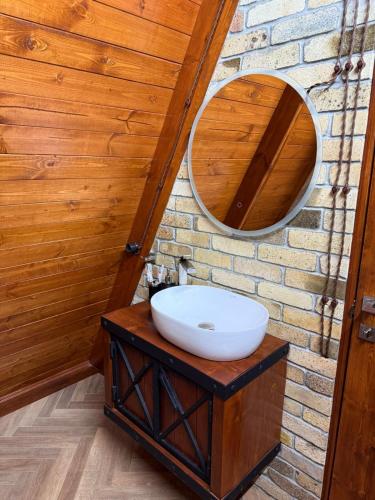 a bathroom with a sink and a mirror on a brick wall at Sayat Nova Home in Dilijan