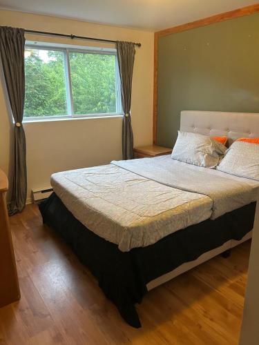 a bedroom with a large bed with a window at Chalet serenity at Lac Desroches in Saint-Calixte