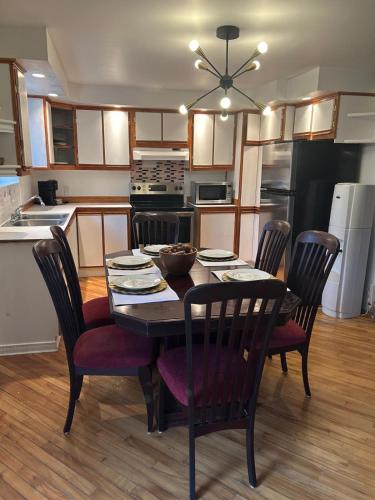 a kitchen with a table with chairs and a dining room at Chalet serenity at Lac Desroches in Saint-Calixte