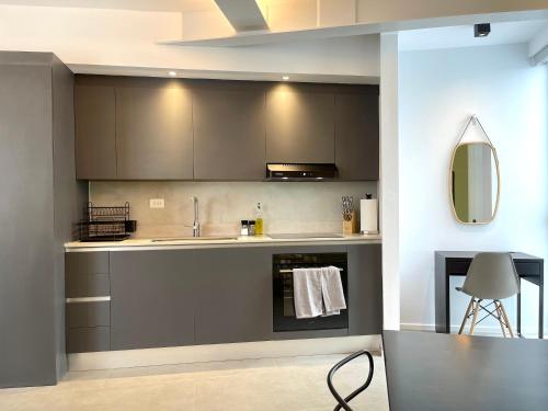 a kitchen with gray cabinets and a sink at Lesplanade By Wynwood House in Panama City