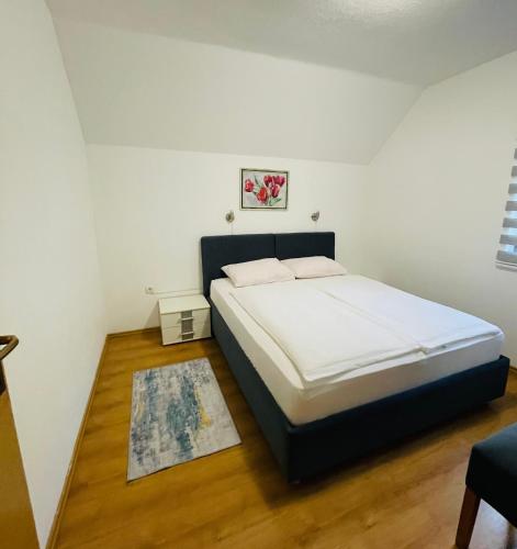 a bedroom with a large bed with white sheets at Holiday Home Ajaz Bihac in Bihać