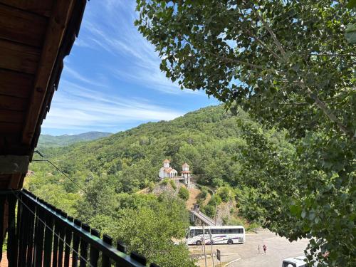 a building on top of a mountain with a bus at Lola in Prolomska Banja