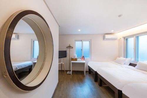 a room with two beds and a mirror at CrashinYongsan guest house in Seoul