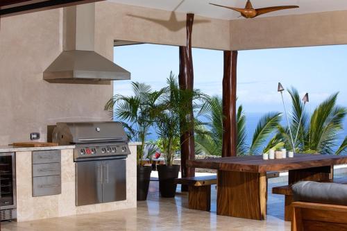 a kitchen with a stove and a table at Hale La'i in Kailua-Kona