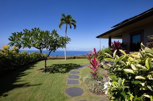 a garden with a walkway next to a house at Hale La'i in Kailua-Kona