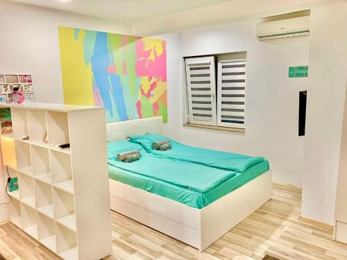 a bedroom with a bed and a colorful wall at City Center Sweet Apartment in Niš