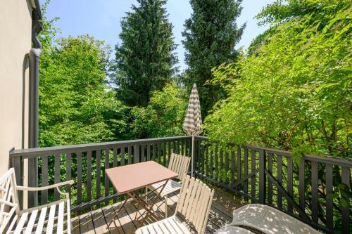 a porch with chairs and a table and trees at Landhaus Hindenburg in Bad Gleichenberg