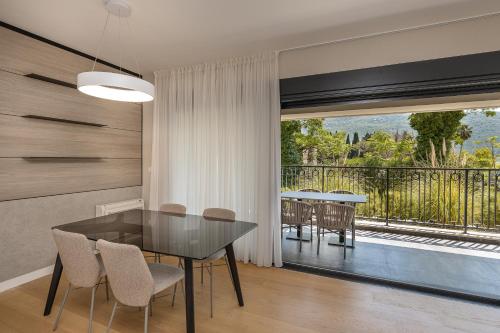 a dining room with a table and chairs and a balcony at Luxury Apartment Sunscape near Portonovi in Herceg-Novi