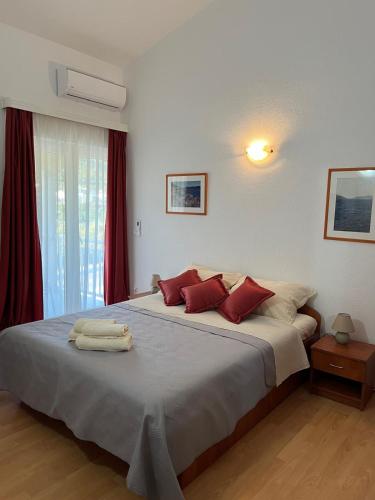 a bedroom with a large bed with red pillows at Rooms Raguž in Neum