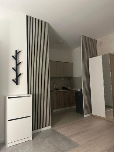 a large kitchen with white walls and wooden floors at Apt 6- Sokobanjica apartmani in Soko Banja