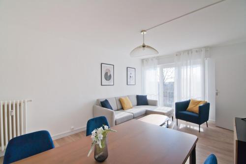 un salon avec un canapé, une table et des chaises dans l'établissement Cosy & stylish F5 Appartement - Troyes center, à Troyes
