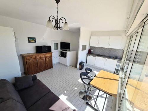 un salon avec un canapé et une table et une cuisine dans l'établissement Résidence Port Nature Village 3 - Villa Duplex 6 Pers. Port Nature Village MAE-2884, au Cap d'Agde