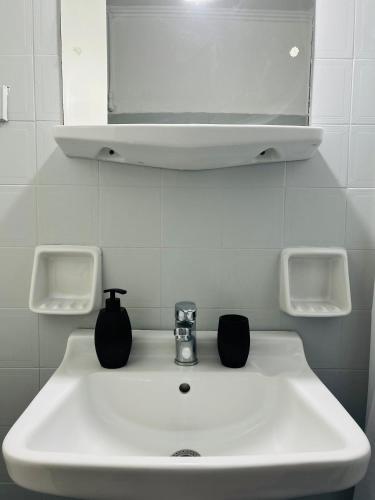 a bathroom sink with two cups on top of it at Paradises's Nest in Agios Georgios