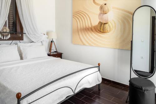a bedroom with a white bed and a mirror at Revery Villa in Ios Chora